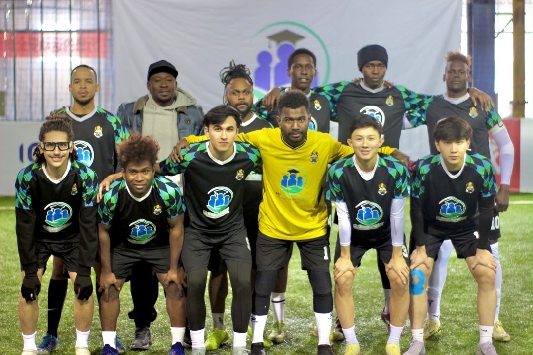 Football team posing in black and green MyDreamAdvisor-sponsored kits